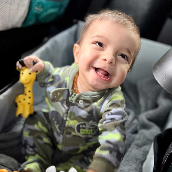 Photograph of Baby Cyrus playing with a toy and smiling
