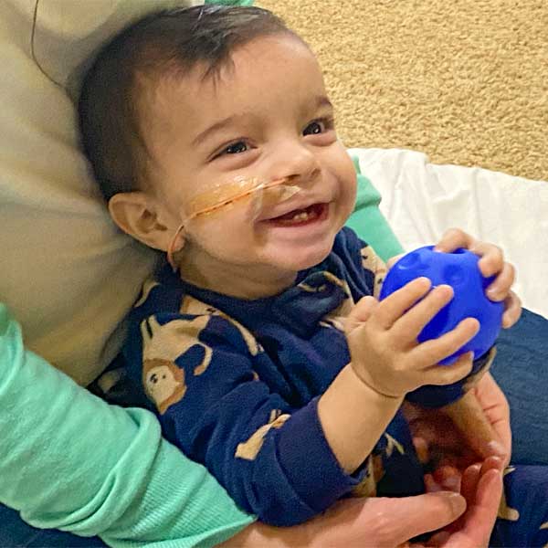 Photograph of Baby Cyrus playing with a blue ball